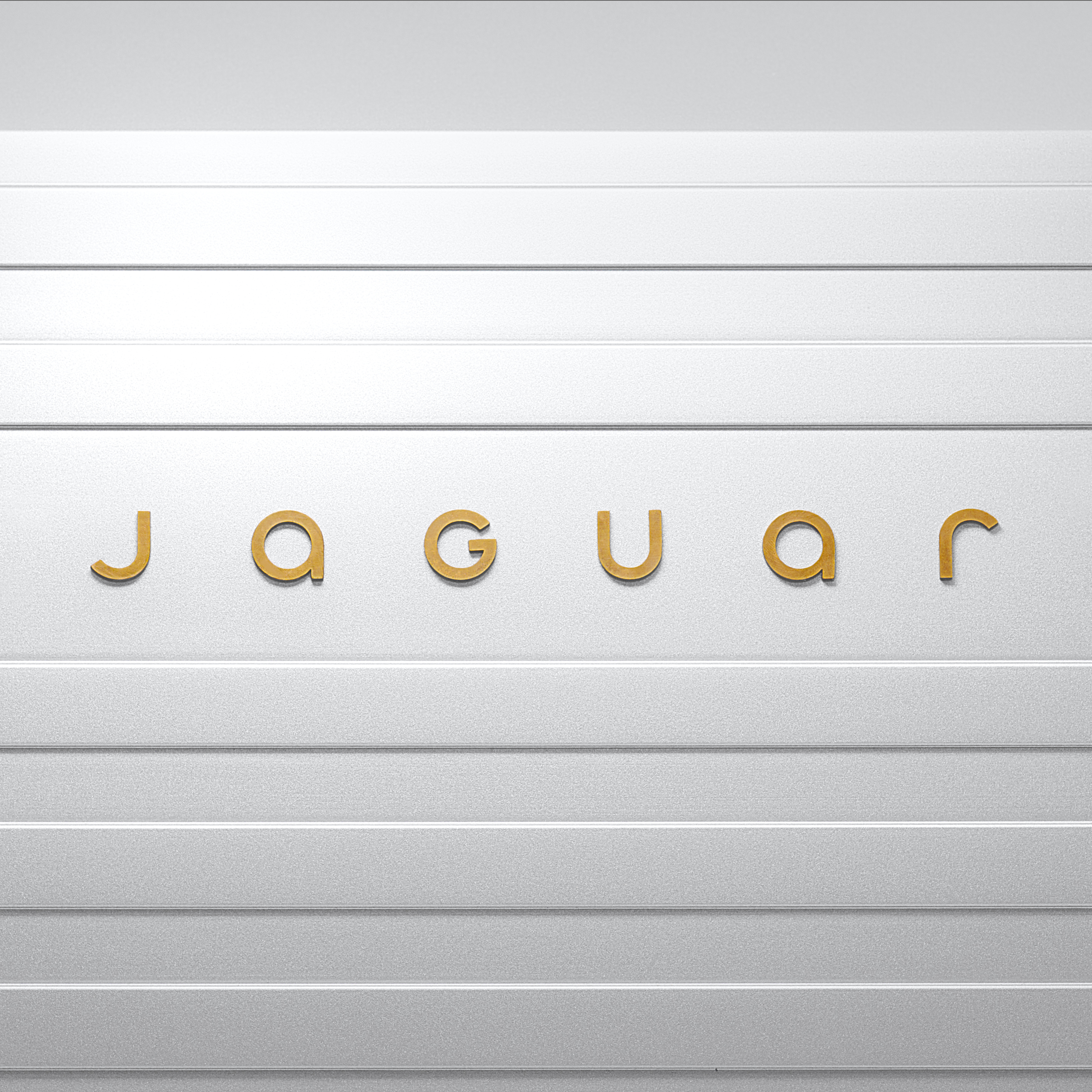 Logotipo oficial da nova Jaguar em dourado com linhas horizontais