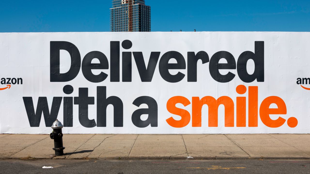 Painel de outdoor com o novo slogan da Amazon indicando um sorriso